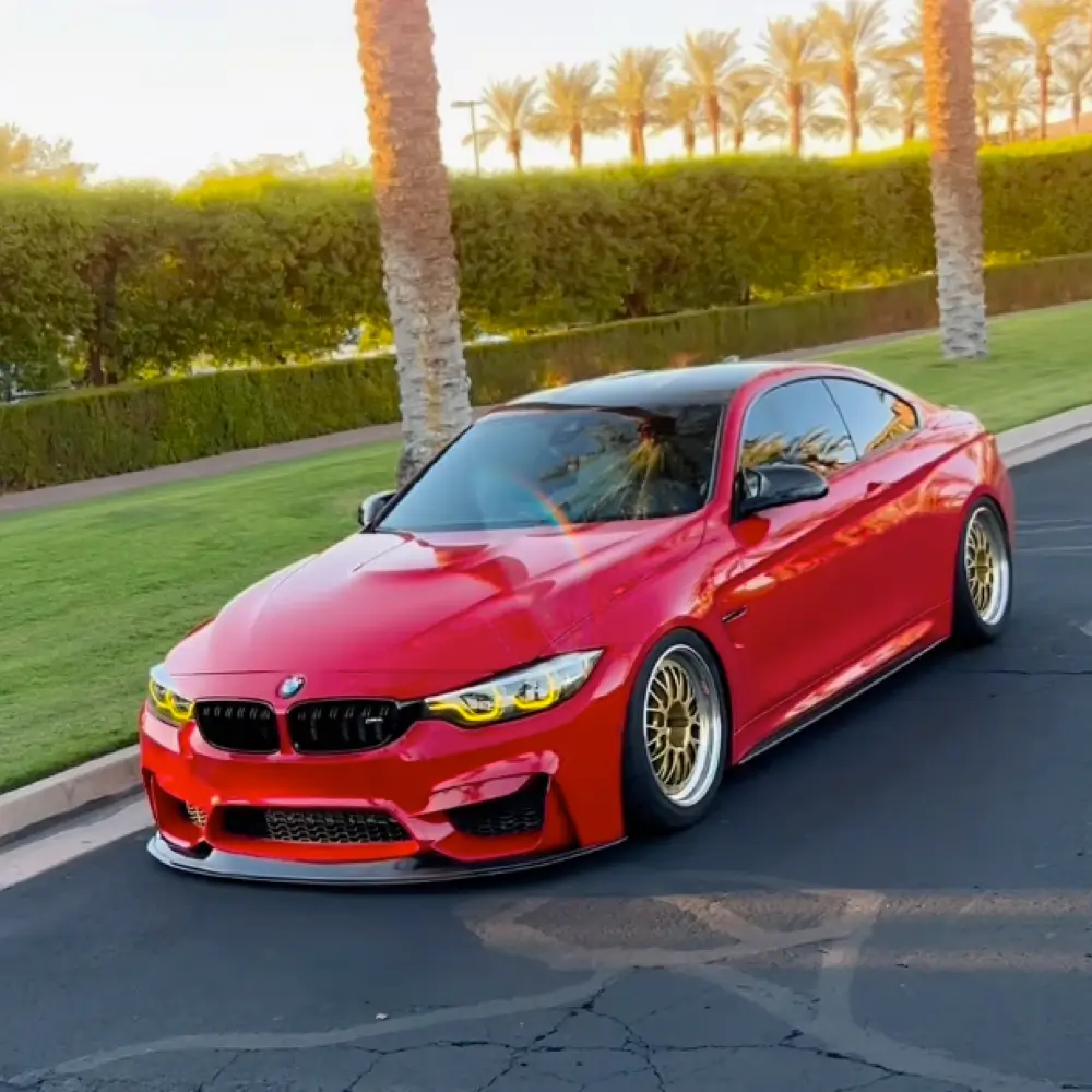Red BMW F82 M4 lowered on gold wheels, an HTP Motorsport build.
