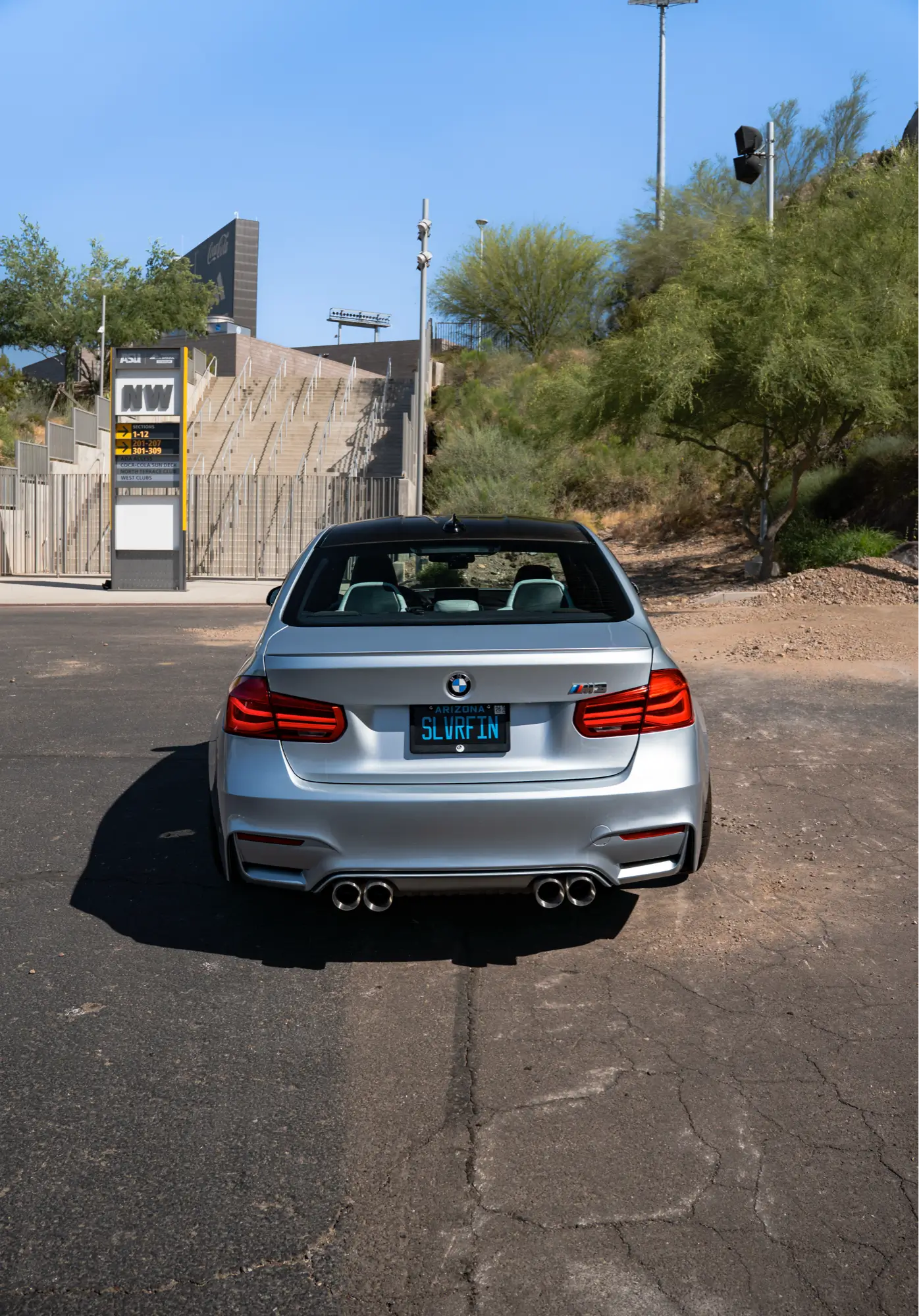 Silver BMW M3 (F80) rear view near a stadium, the kind of performance vehicle HTP Motorsport preps for track days.